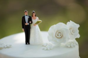 bride and groom cake toppers with white flowers from wedding florist