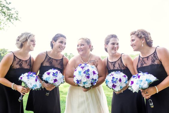 bride and bridesmaids holding wedding flowers at foggy mountain lodge