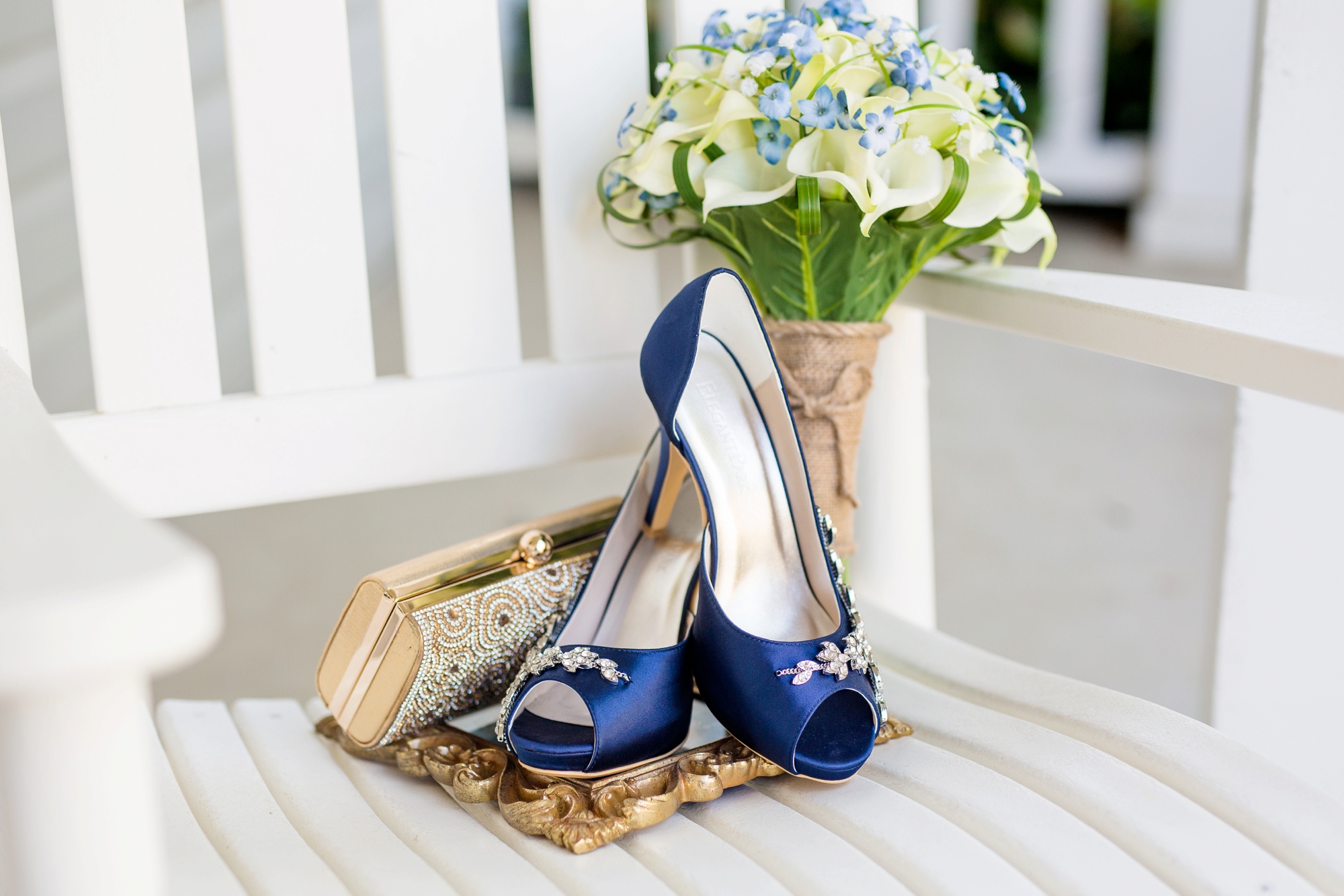 bride's calla lily bouquet and navy wedding shoes on a white rocking chair