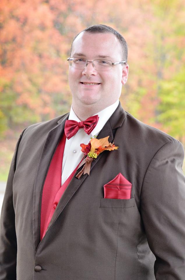 groom in chocolate brown tux with fall boutonniere